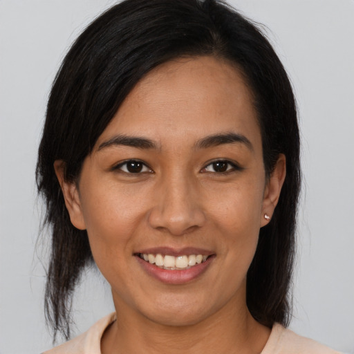 Joyful latino young-adult female with medium  brown hair and brown eyes