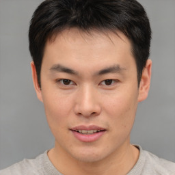 Joyful asian young-adult male with short  brown hair and brown eyes