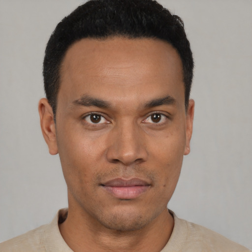 Joyful latino young-adult male with short  black hair and brown eyes