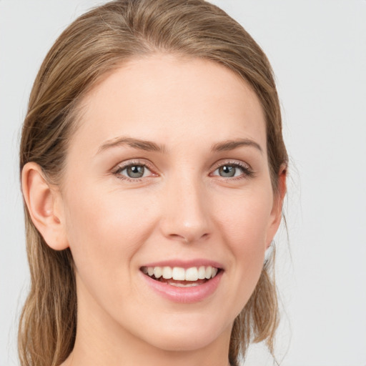 Joyful white young-adult female with medium  brown hair and blue eyes