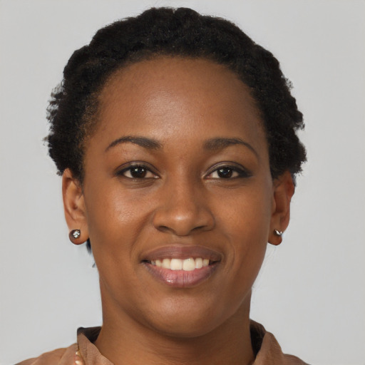 Joyful black young-adult female with short  brown hair and brown eyes