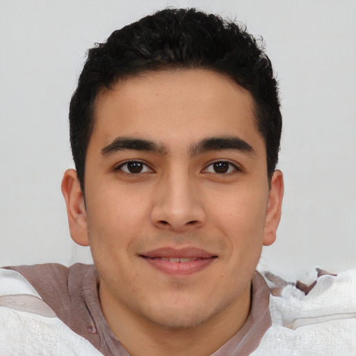 Joyful latino young-adult male with short  black hair and brown eyes
