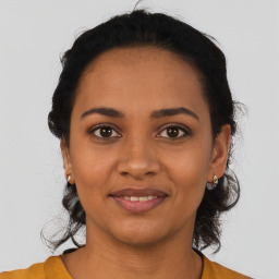 Joyful black young-adult female with short  black hair and brown eyes