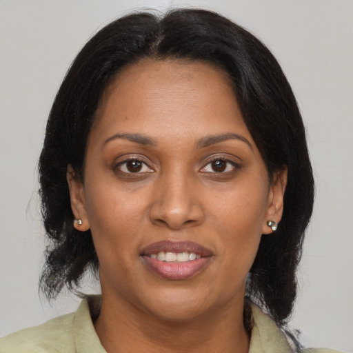 Joyful black adult female with medium  brown hair and brown eyes
