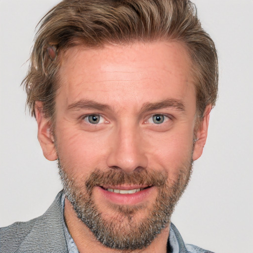 Joyful white adult male with short  brown hair and blue eyes