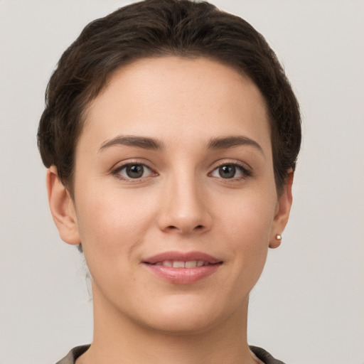 Joyful white young-adult female with short  brown hair and grey eyes