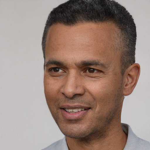 Joyful latino adult male with short  brown hair and brown eyes