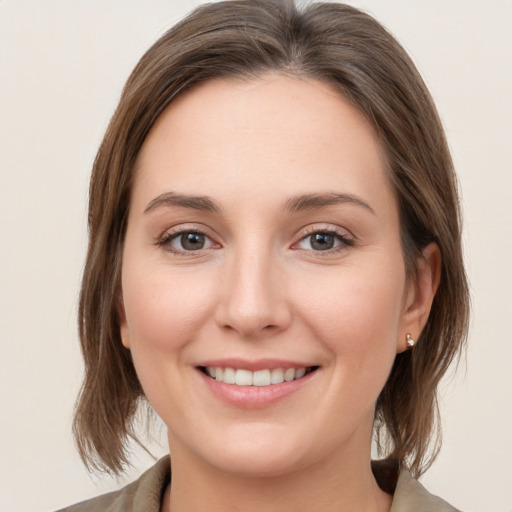 Joyful white young-adult female with medium  brown hair and grey eyes