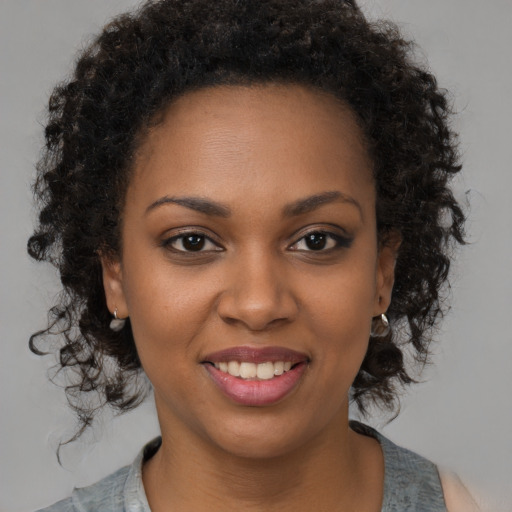 Joyful black young-adult female with medium  brown hair and brown eyes