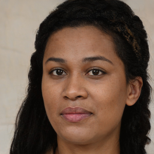 Joyful black young-adult female with long  black hair and brown eyes