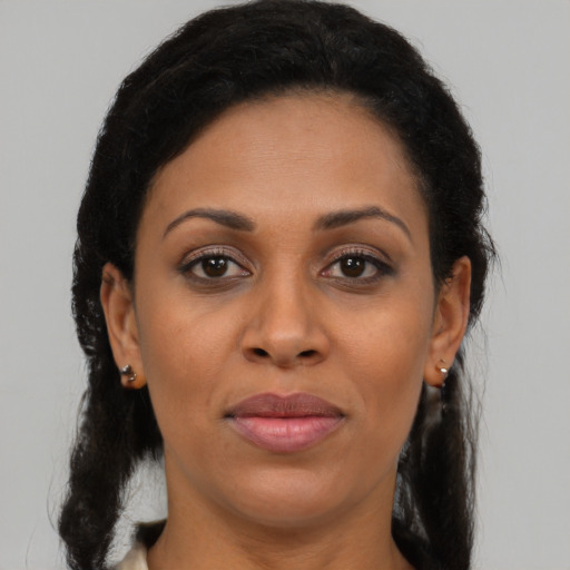 Joyful black young-adult female with long  brown hair and brown eyes