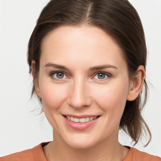 Joyful white young-adult female with medium  brown hair and grey eyes