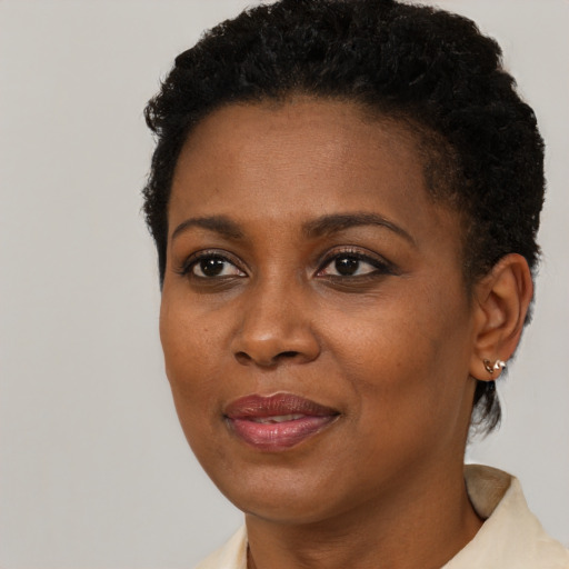 Joyful black young-adult female with short  black hair and brown eyes