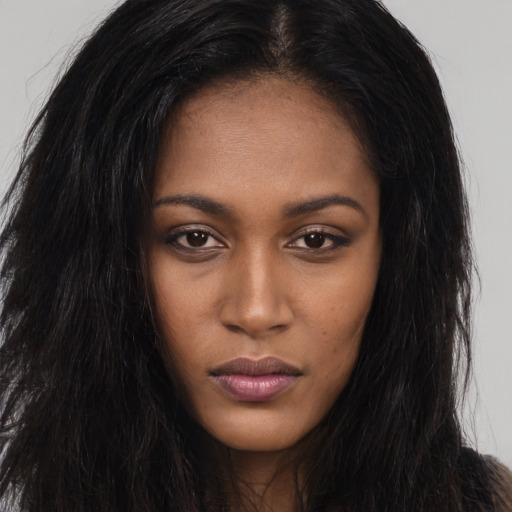 Joyful black young-adult female with long  brown hair and brown eyes