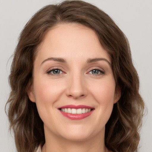 Joyful white young-adult female with medium  brown hair and green eyes