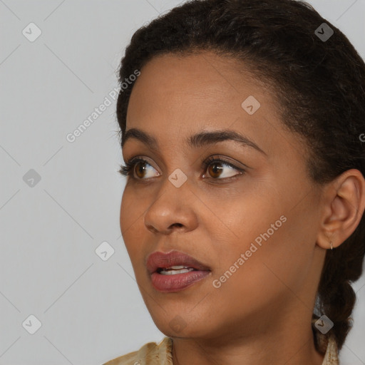 Joyful black young-adult female with long  brown hair and brown eyes