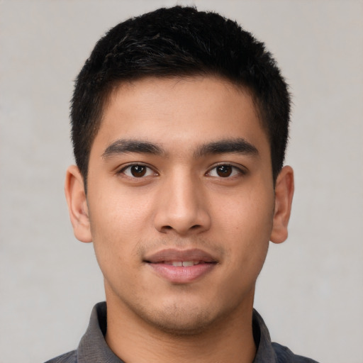 Joyful latino young-adult male with short  black hair and brown eyes