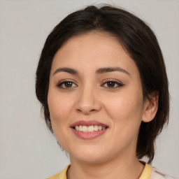 Joyful latino young-adult female with medium  brown hair and brown eyes