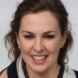 Joyful white adult female with medium  brown hair and brown eyes