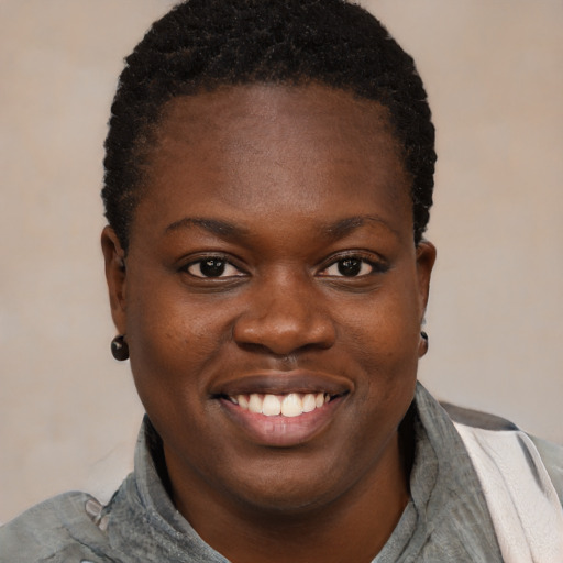 Joyful black young-adult female with short  brown hair and brown eyes