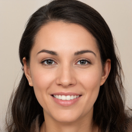 Joyful white young-adult female with long  brown hair and brown eyes