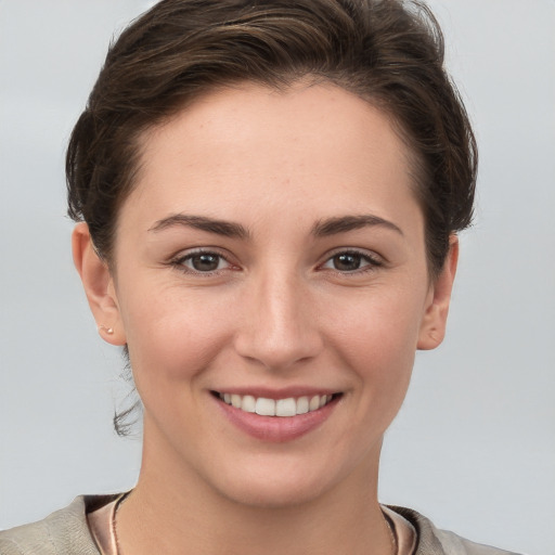 Joyful white young-adult female with short  brown hair and grey eyes