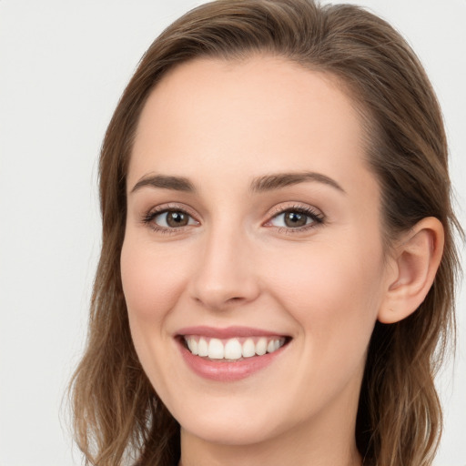 Joyful white young-adult female with long  brown hair and blue eyes