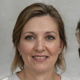 Joyful white adult female with medium  brown hair and grey eyes