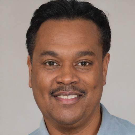 Joyful latino adult male with short  black hair and brown eyes