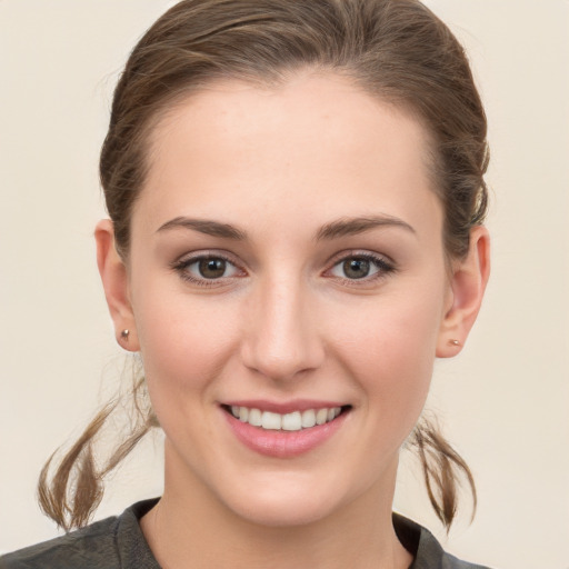 Joyful white young-adult female with medium  brown hair and grey eyes