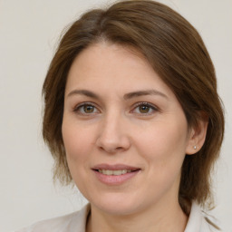 Joyful white young-adult female with medium  brown hair and green eyes