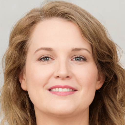 Joyful white young-adult female with long  brown hair and green eyes