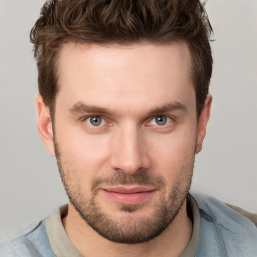 Joyful white young-adult male with short  brown hair and grey eyes