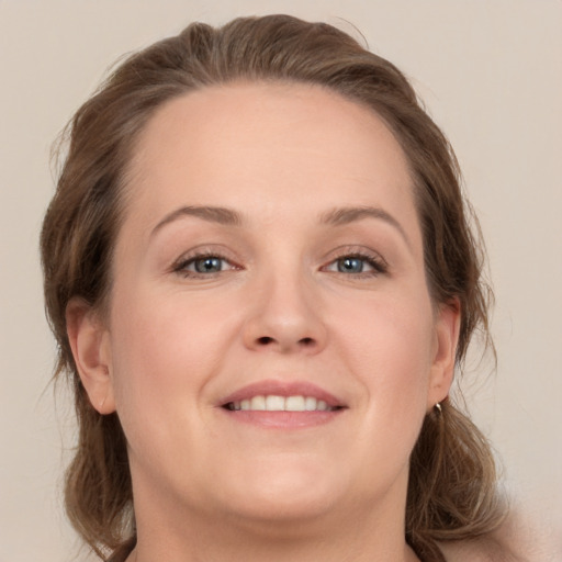 Joyful white young-adult female with medium  brown hair and grey eyes