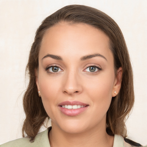 Joyful white young-adult female with long  brown hair and green eyes