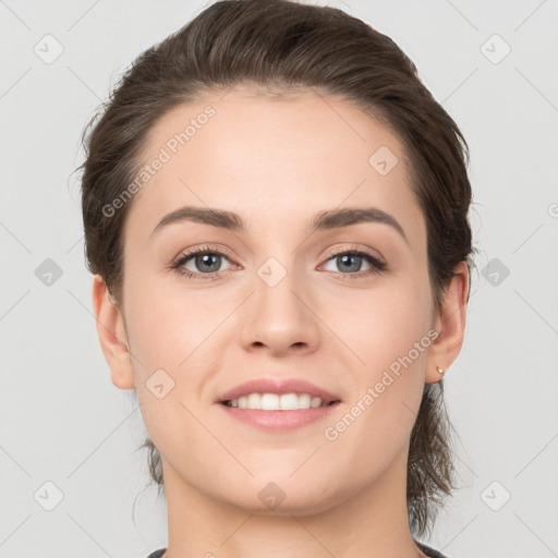 Joyful white young-adult female with medium  brown hair and grey eyes