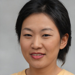 Joyful asian young-adult female with medium  brown hair and brown eyes