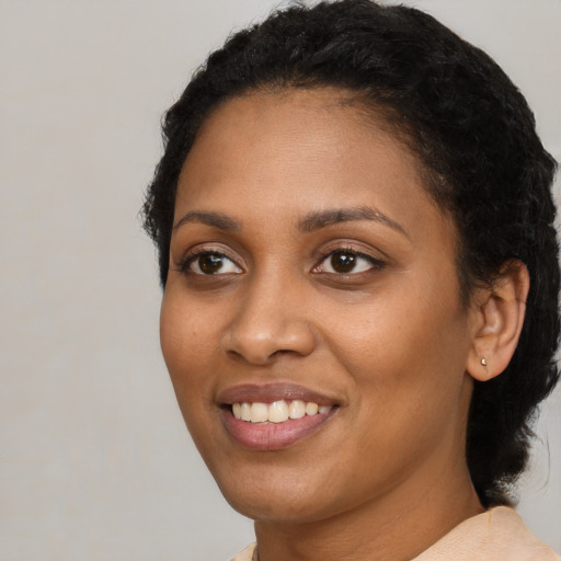 Joyful black young-adult female with medium  black hair and brown eyes