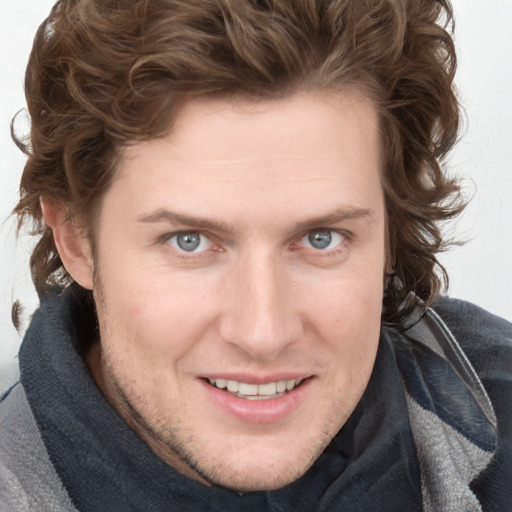 Joyful white young-adult male with medium  brown hair and blue eyes