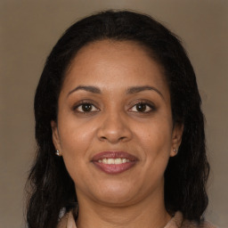 Joyful black adult female with long  brown hair and brown eyes