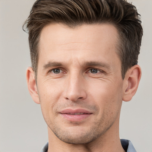 Joyful white young-adult male with short  brown hair and grey eyes