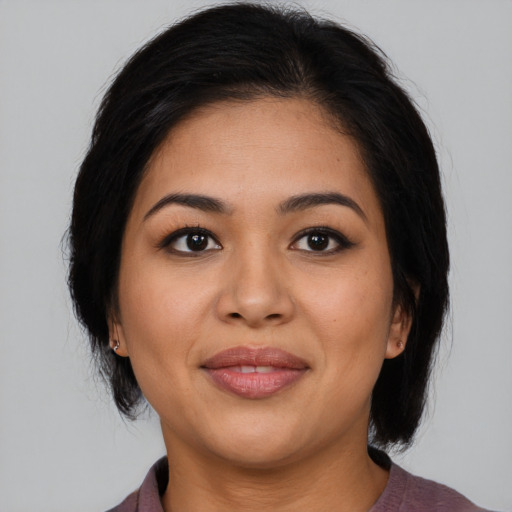 Joyful latino young-adult female with medium  brown hair and brown eyes