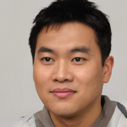 Joyful asian young-adult male with short  black hair and brown eyes