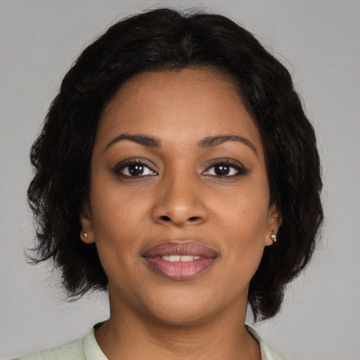 Joyful black young-adult female with medium  black hair and brown eyes