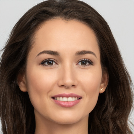 Joyful white young-adult female with long  brown hair and brown eyes