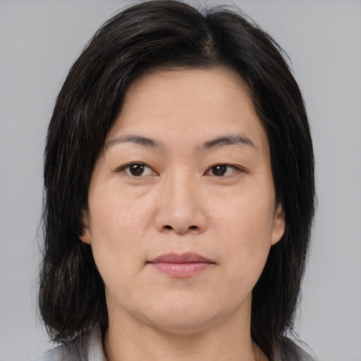 Joyful asian adult female with medium  brown hair and brown eyes