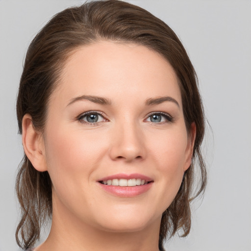 Joyful white young-adult female with medium  brown hair and grey eyes