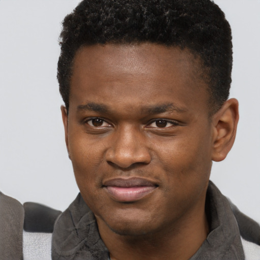Joyful black young-adult male with short  brown hair and brown eyes