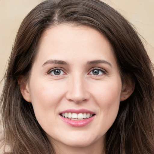 Joyful white young-adult female with long  brown hair and grey eyes