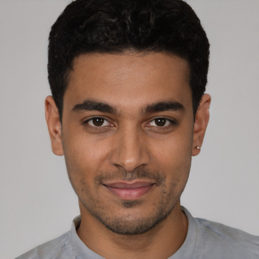 Joyful latino young-adult male with short  black hair and brown eyes